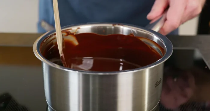 Geschmolzene Schokolade-Butter-Mischung zur Eiermasse geben und verrühren. (101.84)