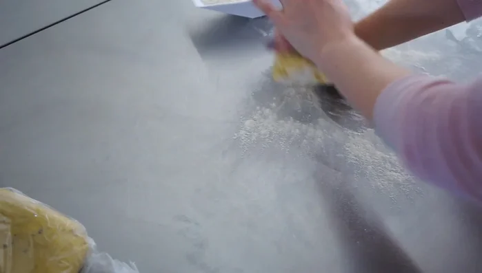 Teig ausrollen: Den kalten Mürbteig halbieren. Die Hälfte auf einer bemehlten Fläche ausrollen (ca. 6-8 mm dick). Den Teig in den Tortenring legen und mit einer Gabel einstechen.