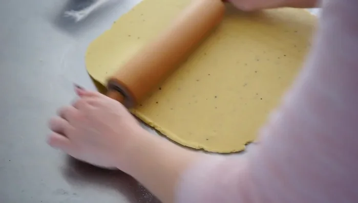 Deckel ausrollen und legen: Die zweite Hälfte des Teigs ausrollen und als Deckel auf die Füllung legen. Übrigen Teig zu Keksen verarbeiten.