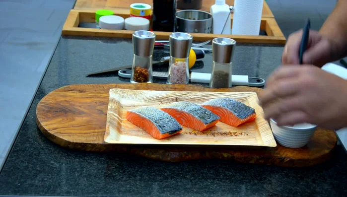 Lachs mit der Hautseite zuerst auf den heißen Grill legen.