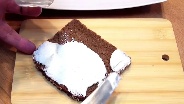 Frischkäse (optional mit Meerrettich) auf das Brot streichen.