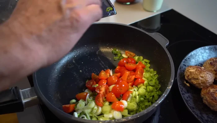 Frühlingslauch und Tomaten in der Pfanne kurz anschwitzen (341.44).