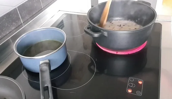 Gemüsebrühe hinzufügen, bei mittlerer Hitze ca. 12 Minuten köcheln lassen, dabei regelmäßig umrühren.