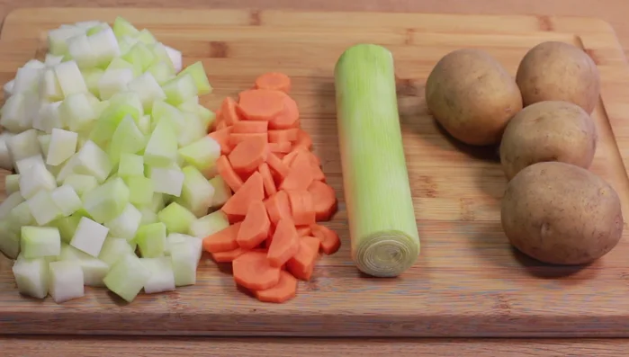 Kohlrabi schälen und in mundgerechte Würfel schneiden. Karotte putzen/schälen und würfeln oder in Scheiben schneiden. Porree in dünne Ringe schneiden. Kartoffeln schälen und würfeln. (80.51)