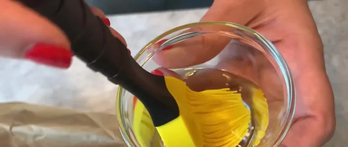 Die Oberfläche des Teigs mit Wasser bestreichen.