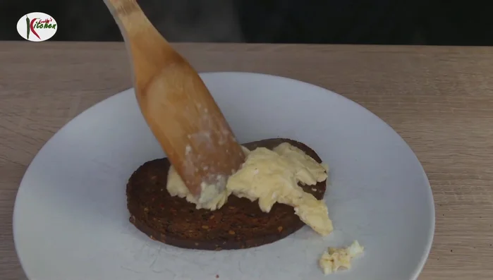 Rührei auf dem gerösteten Schwarzbrot verteilen.