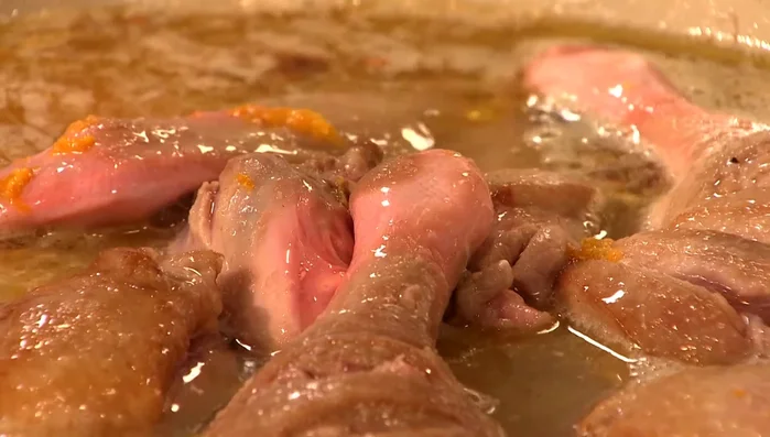 Mit Wein, Orangensaft und etwas Wasser aufgießen und zugedeckt ca. 45 Minuten schmoren, bis das Fleisch weich und die Soße eingedeckt ist. (80.87)