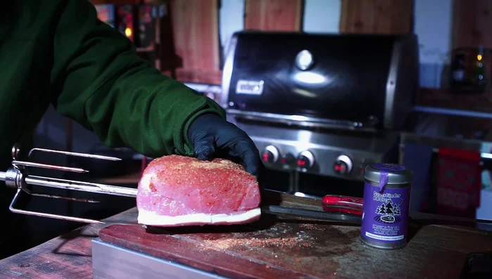 Den Braten auf den Drehspieß im Kugelgrill befestigen. Indirekte Hitze verwenden.