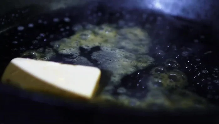 Butter in der Pfanne zerlassen, Champignons darin anbraten.