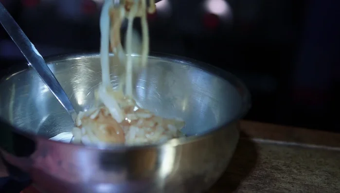 Die angebratenen Zwiebeln zu den Champignons geben.