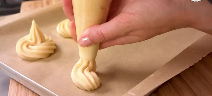 Teig in einen Spritzbeutel füllen und auf ein Backblech spritzen. Bei 200°C Umluft ca. 30 Minuten backen. (231.78)