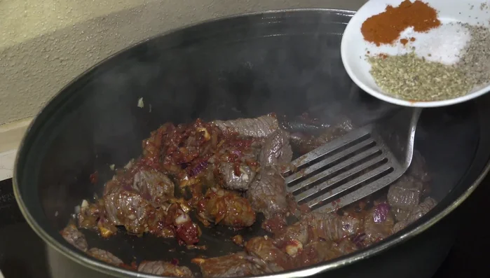 Mit Paprikapulver, Salz, Pfeffer und Majoran würzen.