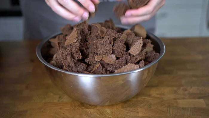 Abgekühlten Biskuit zerpflücken und mit Marmelade und geschmolzener Schokolade vermischen.