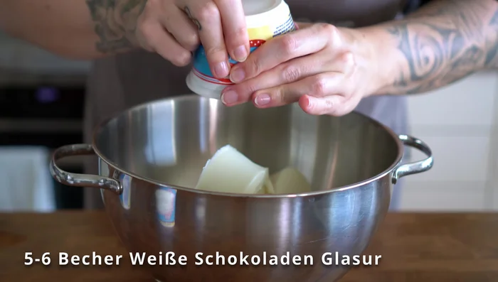 Weiße Schokoladenglasur schmelzen und mit Lebensmittelfarbe einfärben.