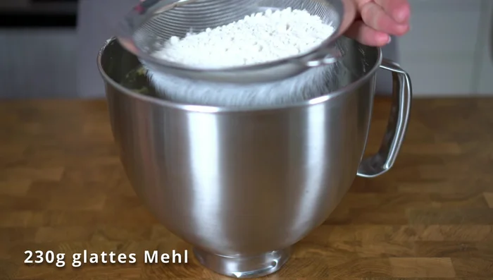 Mehl sieben und unterheben. Teig in Backform verteilen und glatt streichen.