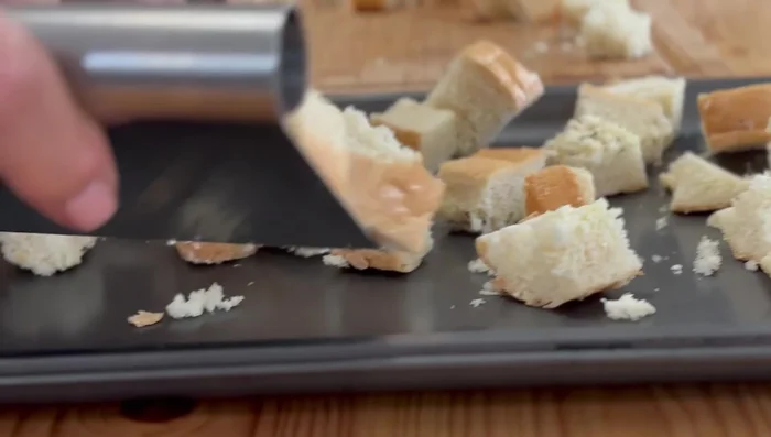 Knoblauchbrotstücke gleichmäßig auf ein Backblech verteilen und für einige Minuten im Ofen rösten. (80.4)