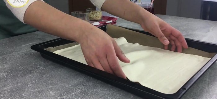 Blätterteig auf ein mit Backpapier ausgelegtes Backblech legen und leicht ausrollen.