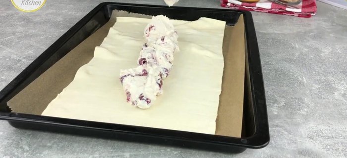 Die Kirschmasse auf den Blätterteig streichen (Rand frei lassen).