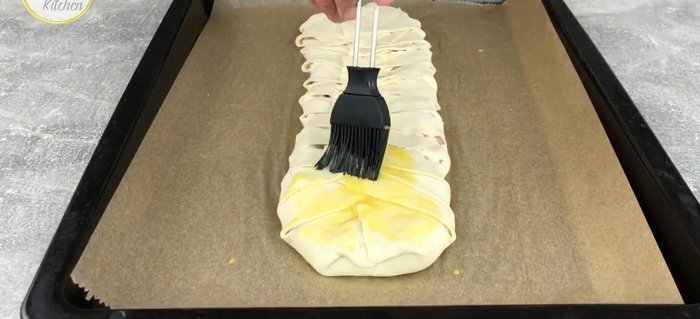 Den Strudel mit verquirltem Eigelb bestreichen und mit Mandelblättchen bestreuen.