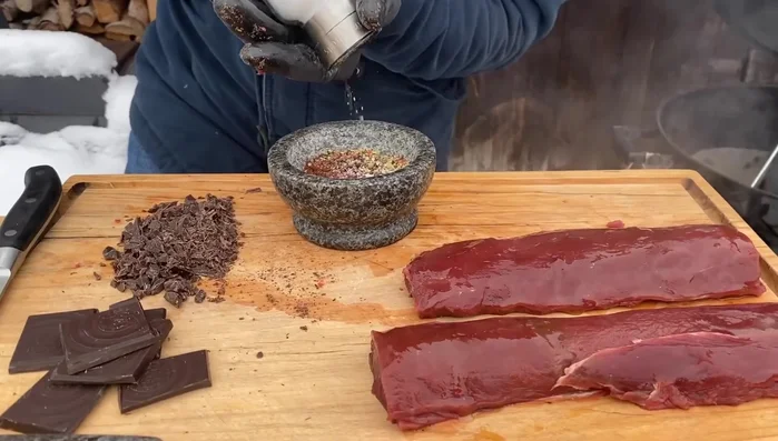 Die Schokoladen-Pfeffer-Mischung auf den Rehrücken verteilen.