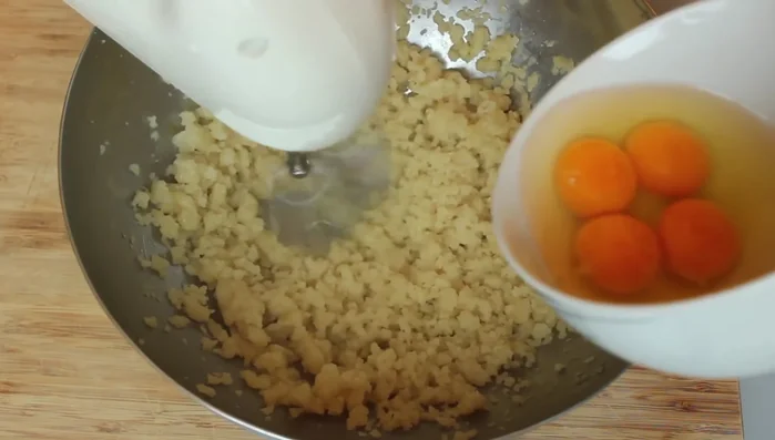 Die Eier nach und nach unter den abgekühlten Brandteig rühren. (170.4)