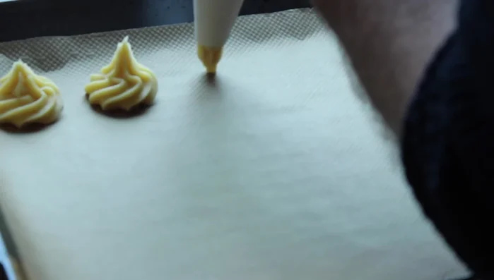 Windbeutel auf ein mit Backpapier belegtes Backblech spritzen. (323.089)