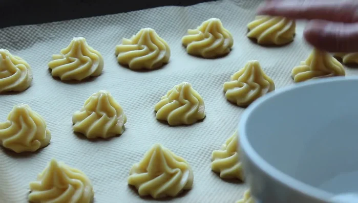 Die Spitzen der Windbeutel leicht flach drücken. (338.639)