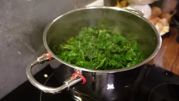 Grünkohl hinzufügen, mit Gemüsebrühe aufgießen und zugedeckt bei geringer Hitze ca. 30 Minuten köcheln lassen (308.22).