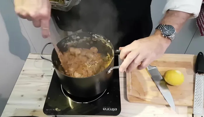 Zitronenabrieb, Majoran, Kümmel, Tomatenmark unterrühren und ebenfalls anschwitzen.