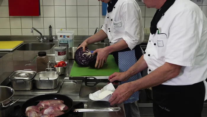 In einer Pfanne mit etwas Rapsöl und Schweineschmalz den Rotkohl mit Zwiebeln und Speck anbraten.