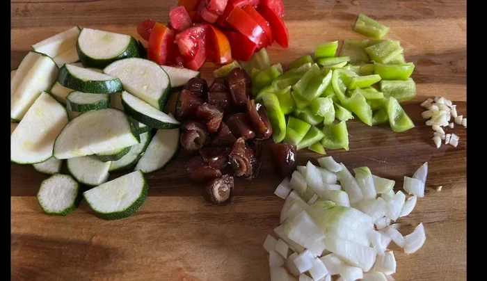 Mediterranes Gemüse (Zucchini, Tomaten, Paprika, Zwiebeln, Knoblauch, Datteln) zubereiten: Zwiebeln anschwitzen, mit Honig und Fischsoße würzen und dünsten.