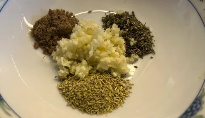 Gewürze (Koriander, Thymian, Rosmarin), gehackten Knoblauch und Salz vermischen.