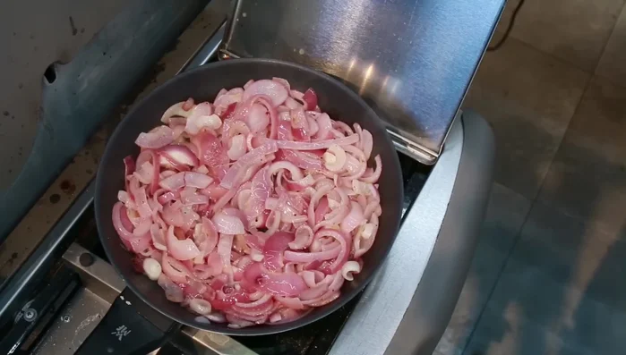 Braunen Zucker, Thymian und Rosmarin zu den Zwiebeln geben und karamellisieren (105.07).