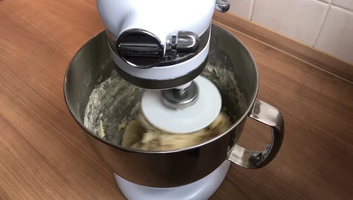 Weiche Butter hinzufügen und den Teig gut durchkneten (KitchenAid Stufe 4 oder von Hand 10-15 Minuten, bis er nicht mehr klebt).