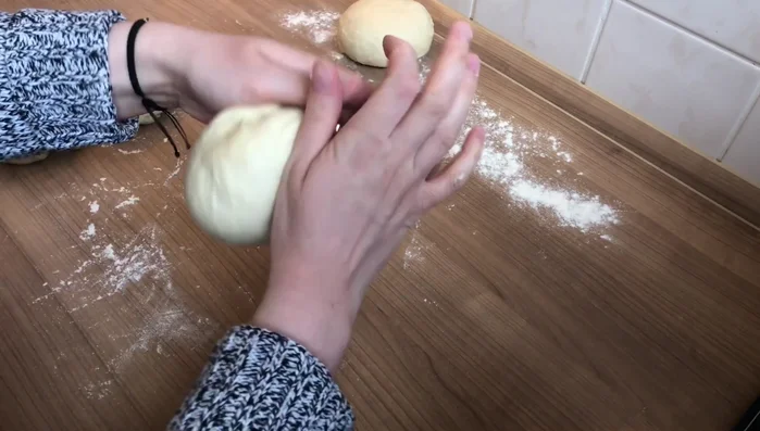 Teig in 4 (oder mehr) gleich große Stücke teilen, zu Kugeln formen, abdecken und 15 Minuten ruhen lassen.