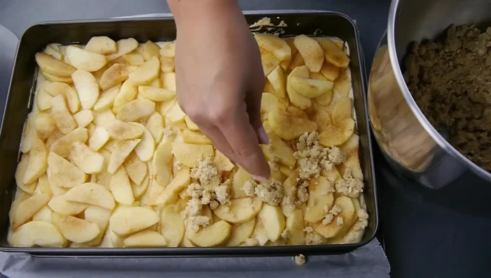 Streusel über die Äpfel verteilen.