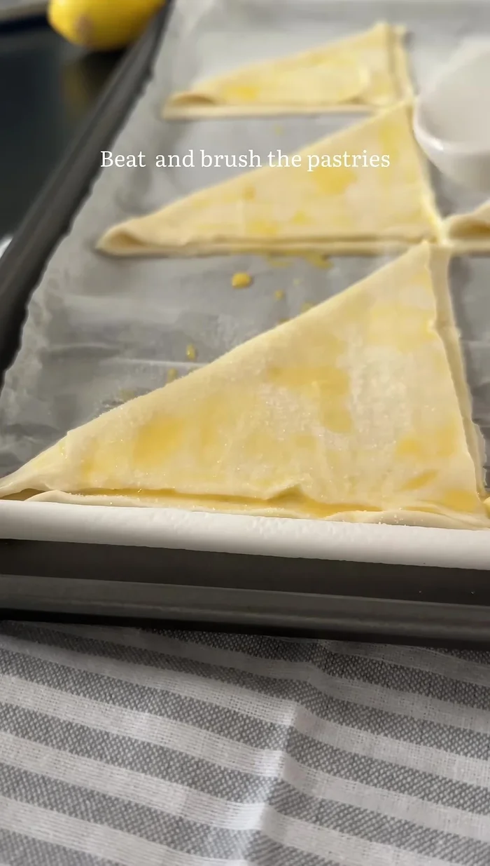 Mit Ei bestreichen und mit Zucker bestreuen. Backen.