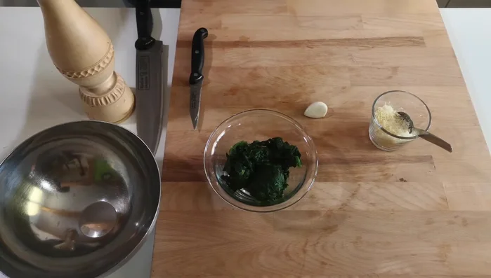Füllung vorbereiten: Spinat, Käse, Knoblauch, Gewürze vermengen.