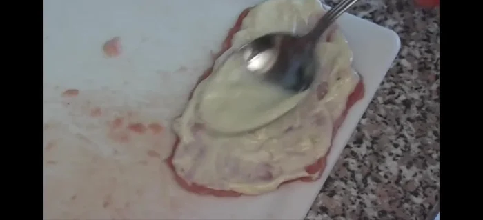 Schnitzel in die Form legen und mit der Knoblauch-Mayonnaise-Mischung bestreichen (50.64).