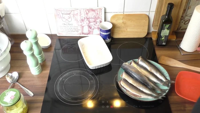 Zitronensaft über die Heringe träufeln, um den Geschmack zu intensivieren. (Alternativ: Zitrone auspressen).