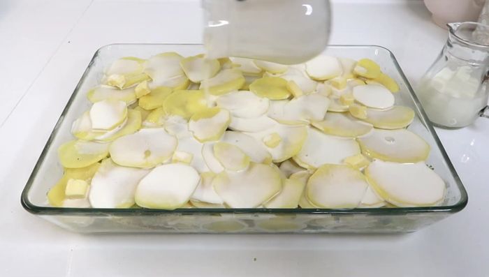 Sahne und Milch darüber verteilen (Alternativ: Brühe). Reichlich Gratin Käse darüber streuen.
