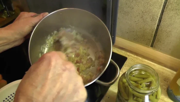 Zwiebeln zum Speck geben und mitbraten.