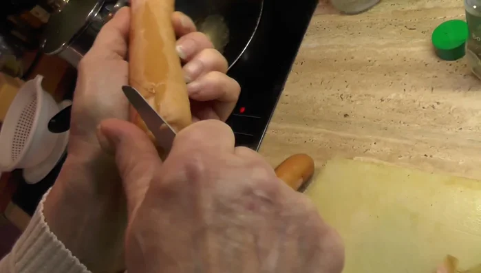 Würstchen schälen und in Scheiben schneiden.