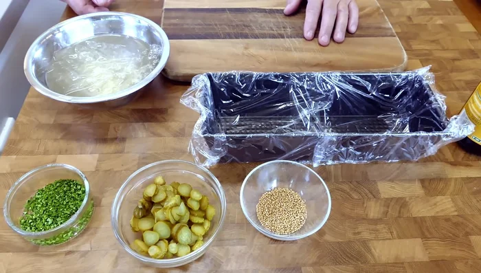 Für den Sud: Blattgelatine einweichen. Ca. 1 Liter Sud durch ein Sieb passieren. Essig, Gewürzgurken, Senfsamen und gehackte Petersilie hinzufügen. Abschmecken.