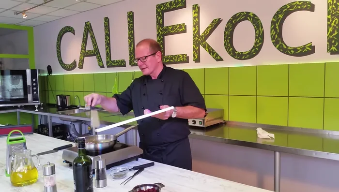 In die Pfanne: fein geschnittene rote Zwiebeln geben und anschwitzen. Zerstoßenen grünen Pfeffer hinzufügen.