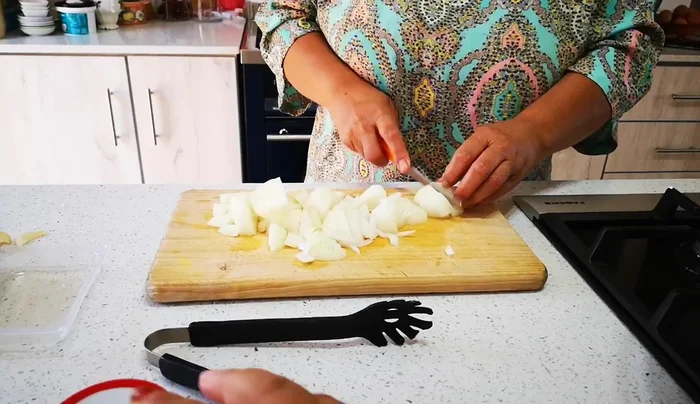 Grob gehackte Zwiebeln und Knoblauch zum Fleisch geben und mitbraten.