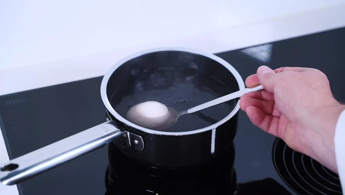 Eier in kochendes Wasser geben und 6 Minuten 20 Sekunden köcheln lassen. Die Eier sollten innen noch wachsweich sein.