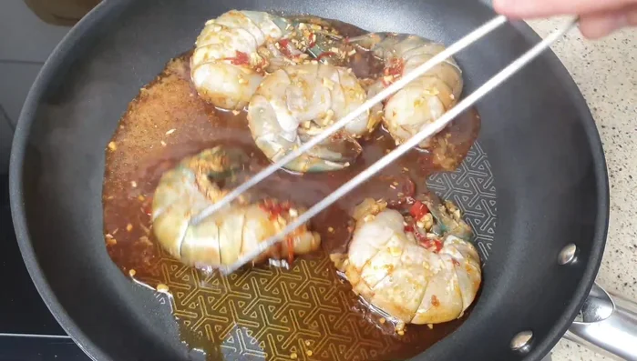 Garnelen in einer Pfanne bei mittlerer Hitze braten. Dabei darauf achten, dass der Honig nicht verbrennt.