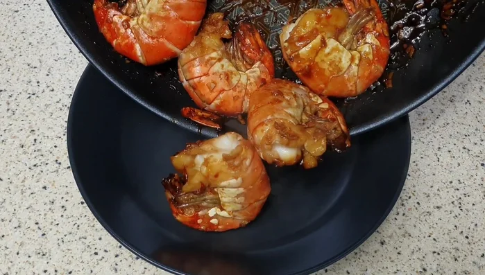 Die fertigen Garnelen mit der restlichen Marinade beträufeln und servieren.