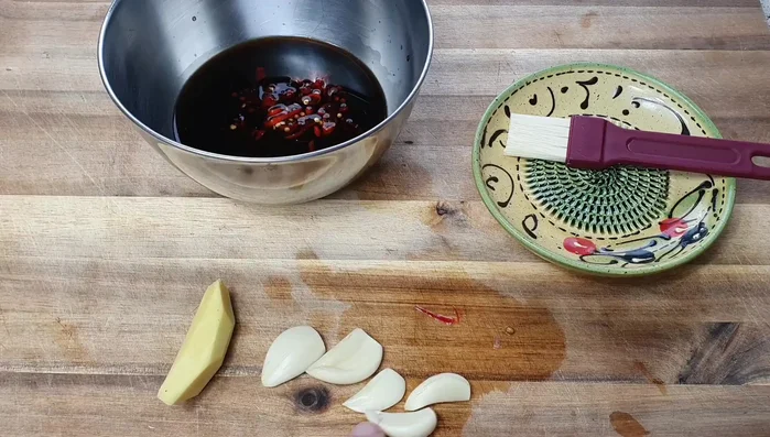 Knoblauch fein hacken und zum Ingwer (gerieben) in die Schüssel geben.
